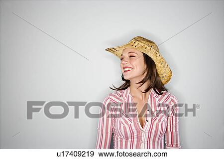 Stock Photo - Young Caucasian woman wearing cowboy hat smiling.. Fotosearch