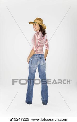 Young Caucasian woman wearing cowboy hat looking over shoulder at viewer and smiling. View Large Photo Image Stock Photography - Young Caucasian woman wearing cowboy hat looking over shoulder at viewer and smiling.. Fotosearch