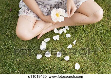 Stock Image - 2 women laughing, laying on grass. Fotosearch