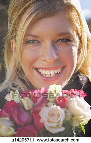 A female smiling holding some roses View Large Photo Image Stock Image - A female smiling holding some roses. Fotosearch