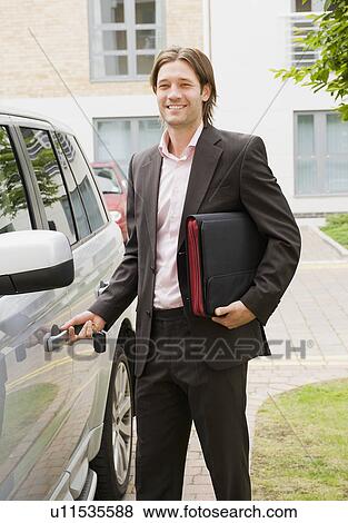 Stock Photo - Business man getting into car. Fotosearch