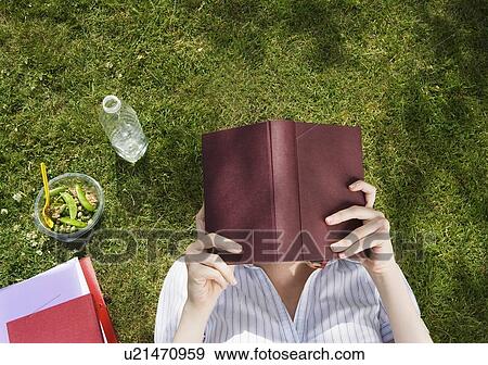 Stock Photo - Business woman reading book in park. Fotosearch