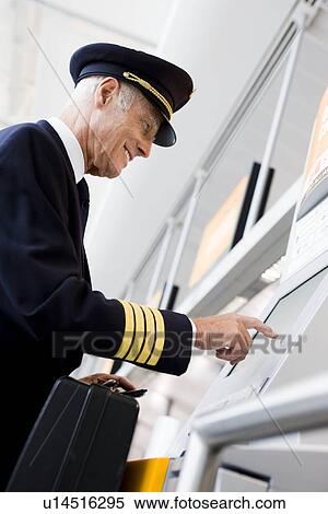 Flight captain using boarding computer View Large Photo Image Stock Photography - Flight captain using boarding computer. Fotosearch