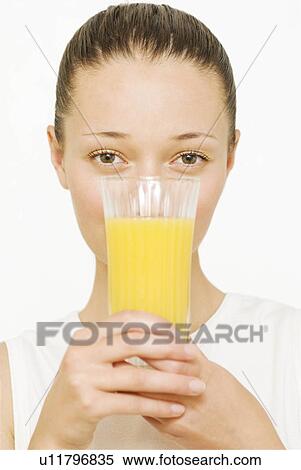 Girl holding a glass of orange juice View Large Photo Image Stock Photography - Girl holding a glass of orange juice. Fotosearch