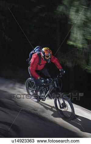 Stock Image - Mountain biker riding fast. Fotosearch