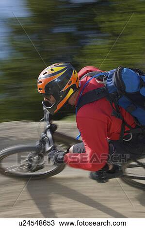 Stock Image - Mountain biker riding fast. Fotosearch