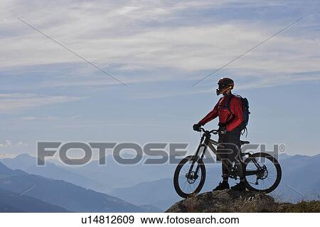 Mountain biker taking in the view View Large Photo Image Stock Photo - Mountain biker taking in the view. Fotosearch