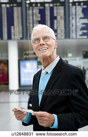 Stock Image - Older man holding ticket. Fotosearch