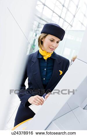 Stewardess looking at display View Large Photo Image Stock Photograph - Stewardess looking at display. Fotosearch