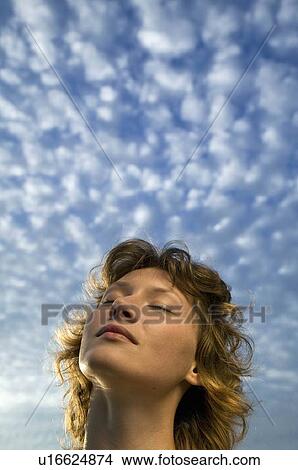Picture - Woman and clouds in a blue sky. Fotosearch