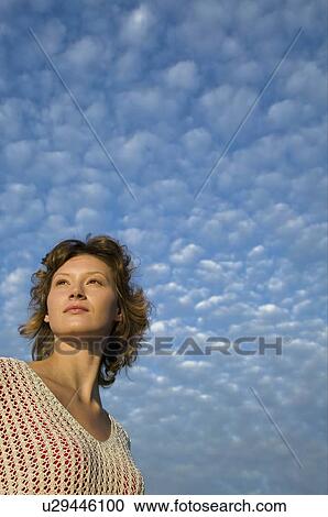 Stock Image - Woman and clouds in a blue sky. Fotosearch