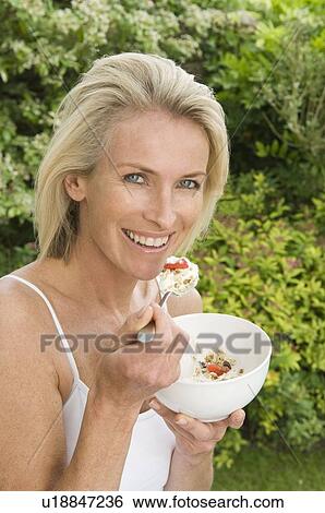 Woman eating fruit and muesli View Large Photo Image Stock Photograph - Woman eating fruit and muesli. Fotosearch