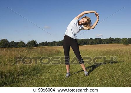 Picture - Woman runner doing stretching exercises. Fotosearch