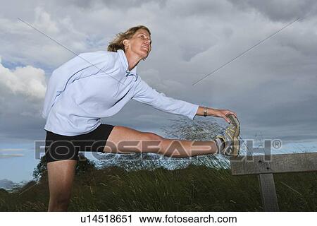 Woman runner doing stretching exercises View Large Photo Image Stock Image - Woman runner doing stretching exercises. Fotosearch