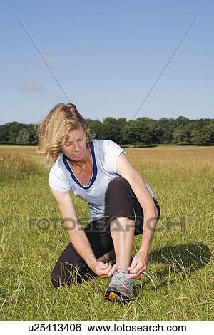 Woman runner doing up shoe lace View Large Photo Image Stock Photograph - Woman runner doing up shoe lace. Fotosearch