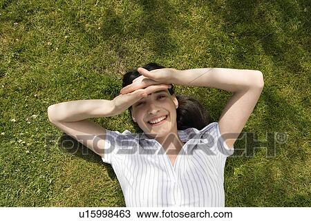 Stock Image - Woman shielding eyes with hands . Fotosearch