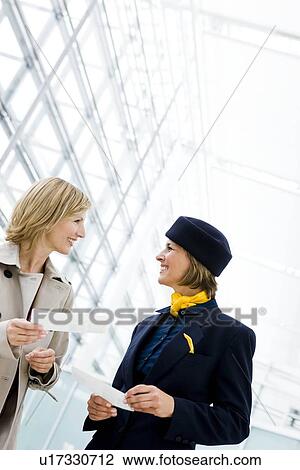 Woman talking to stewardess View Large Photo Image Stock Image - Woman talking to stewardess. Fotosearch