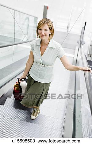 Woman walking an escalator View Large Photo Image Stock Image - Woman walking an escalator. Fotosearch