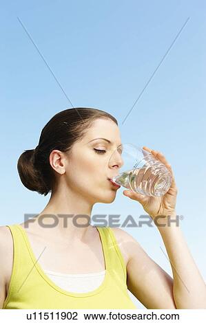 Stock Image - Young woman drinking glass of water. Fotosearch