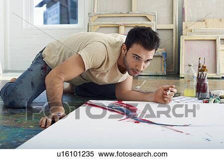 Stock Photography - Artist painting on canvas on studio floor. Fotosearch