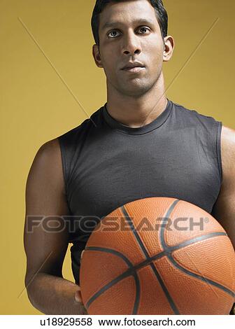 Stock Photo - Athlete holding basketball. Fotosearch