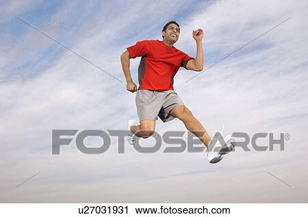 Stock Image - Athlete running mid-air. Fotosearch
