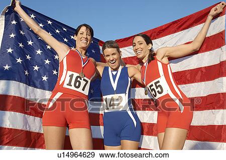 Athletes celebrating with medals and American flag View Large Photo Image Stock Photo - Athletes celebrating with medals and American flag. Fotosearch