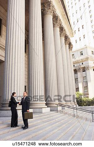 Stock Photo - Attorneys shaking hands on courthouse steps. Fotosearch
