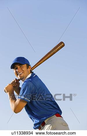 Baseball player swinging baseball bat (low angle view) View Large Photo Image Picture - Baseball player swinging baseball bat (low angle view). Fotosearch