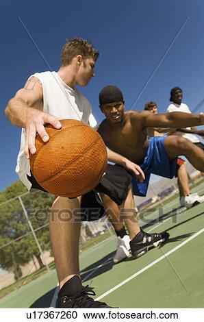 Stock Image - Basketball player dribbling ball. Fotosearch
