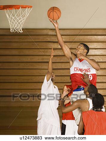 Stock Image - Basketballer performing lay-up in match. Fotosearch