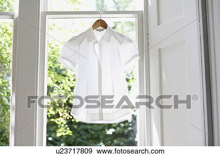 Blouse on Hanger in domestic window View Large Photo Image Stock Photo - Blouse on Hanger in domestic window. Fotosearch