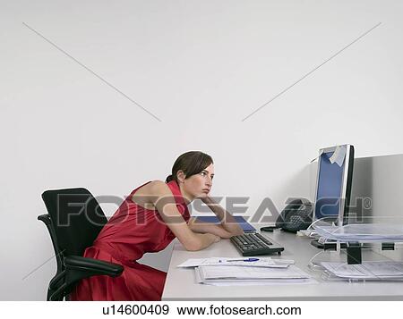 Stock Photo - Bored office worker at desk in office. Fotosearch