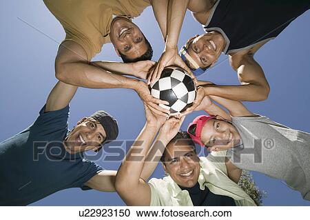Boy (13-15) with brothers and father holding soccer ball together view from below. View Large Photo Image Stock Image - Boy (13-15) with brothers and father holding soccer ball together view from below.. Fotosearch