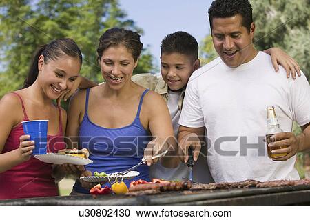 Boy (13-15) with family at outdoor grill. View Large Photo Image Stock Image - Boy (13-15) with family at outdoor grill.. Fotosearch