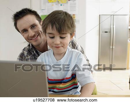 Stock Photo - Boy (3-6) using laptop with father at home (portrait). Fotosearch