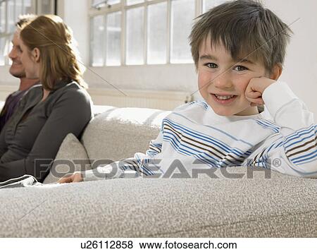Boy (3-6) with parents on couch smiling (portrait) View Large Photo Image Stock Photo - Boy (3-6) with parents on couch smiling (portrait). Fotosearch