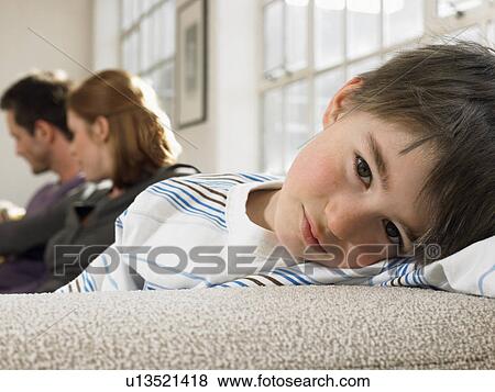 Boy (3-6) with parents on couch (portrait) View Large Photo Image Stock Photo - Boy (3-6) with parents on couch (portrait). Fotosearch