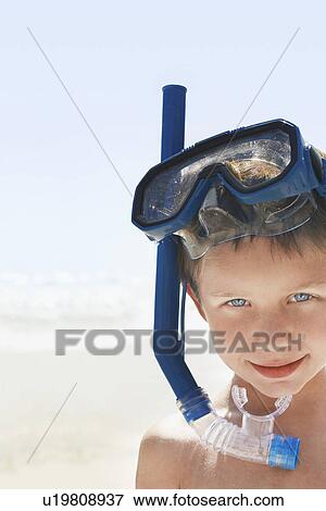 Stock Photo - Boy (5-6 years) wearing snorkeling goggles portrait. Fotosearch