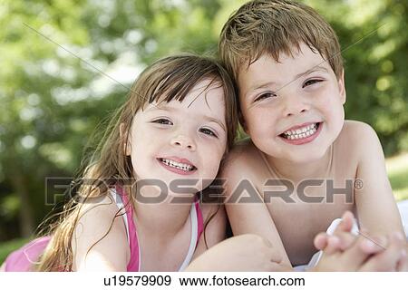 Boy and girl lying in backyard portrait close up View Large Photo Image Stock Photo - Boy and girl lying in backyard portrait close up. Fotosearch