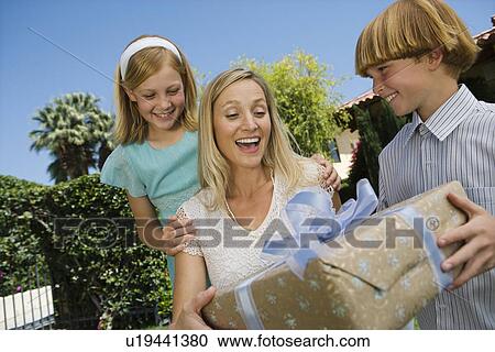 Boy giving birthday present to his mother View Large Photo Image Stock Image - Boy giving birthday present to his mother. Fotosearch
