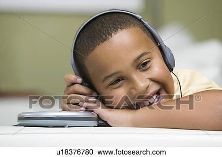 Boy on sofa Listening to portable CD player close up View Large Photo Image Stock Image - Boy on sofa Listening to portable CD player close up. Fotosearch