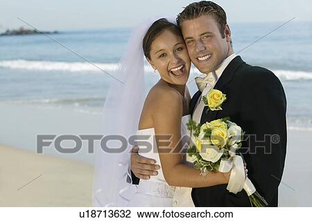 Bride and Groom embracing on beach (portrait) View Large Photo Image Stock Image - Bride and Groom embracing on beach (portrait). Fotosearch