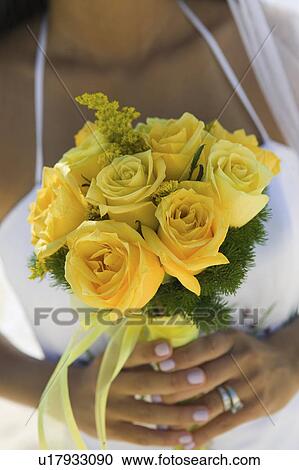Bride holding yellow rose bouquet (close-up) View Large Photo Image Stock Image - Bride holding yellow rose bouquet (close-up). Fotosearch
