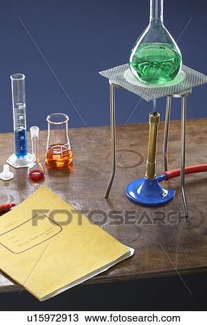 Stock Image - Bunsen burner tripod flask and test tubes in science laboratory. Fotosearch
