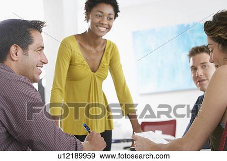 Stock Photo - Business colleagues in office meeting. Fotosearch