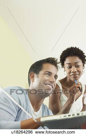 Stock Photograph - Business colleagues working in office low angle view. Fotosearch