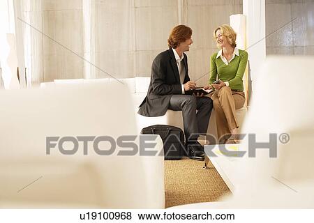 Business couple talking in living room View Large Photo Image Stock Photo - Business couple talking in living room. Fotosearch