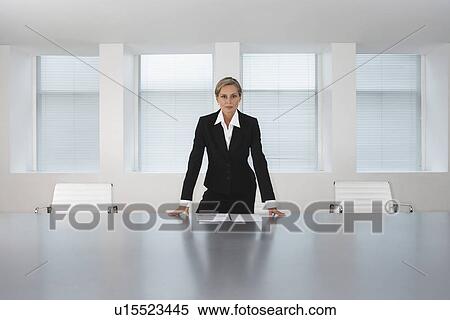 Stock Photography - Business Executive Standing in Conference Room. Fotosearch