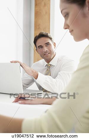 Stock Image - Business man and woman in meeting. Fotosearch